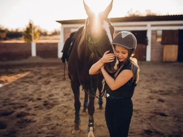 Ragazza durante un camp di equitazione in Inghilterra con lezioni di monta e cura del cavallo