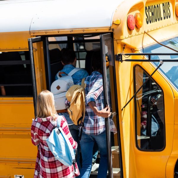 Studenti adolescenti che salgono sul famoso bus giallo americano Studenti adolescenti che salgono sul famoso bus giallo americano
