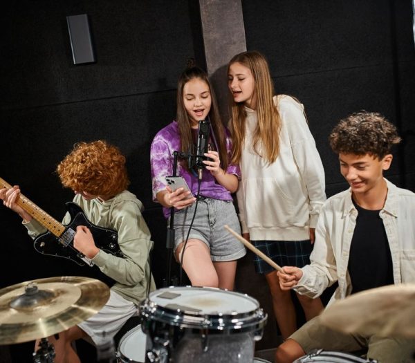 Adolescenti che provano con passione la propria band in uno studio musicale creativo Adolescenti che provano con passione la propria band in uno studio musicale creativo