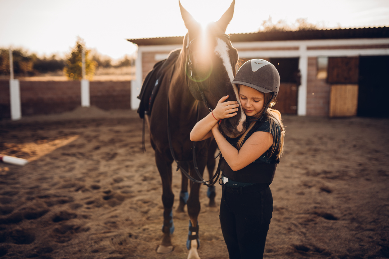 Una ragazza abbraccia il suo cavallo Una ragazza abbraccia il suo cavallo